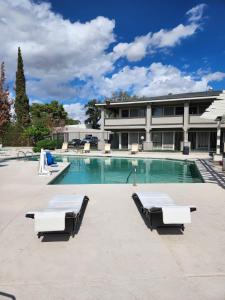 a swimming pool with two lounge chairs and a building at Travelodge by Wyndham Phoenix North in Phoenix