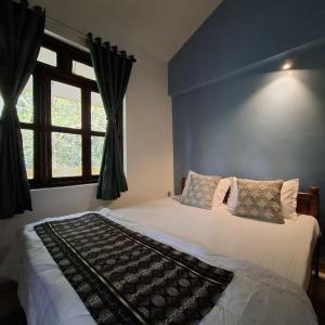 a bedroom with a large bed with a window at Palolem by Casa de Palmora in Canacona