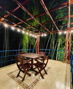 a wooden table on a patio with a view of the jungle at Finca privada de lujo Casalegre in Pance