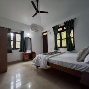 a bedroom with a bed and a ceiling fan at Casa Lua in Canacona