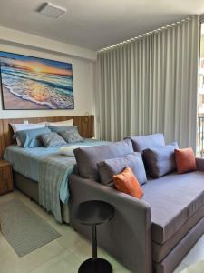 een slaapkamer met een bank en een bed en een bank bij STÚDIO - Novo e Sofisticado! in Princesa dʼOeste