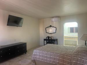 a bedroom with a bed and a tv on the wall at Hotel Colonial 