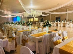 a banquet hall with white tables and white chairs at Hotel Colonial 