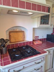 a kitchen with a stove and red tile at Colocation in Trignac