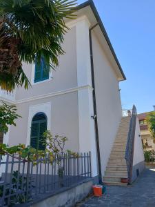 a white house with a staircase in front of it at Grand Tour - Cascata delle Marmore in Le Marmore
