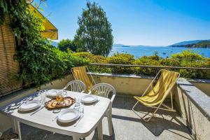 un tavolo e sedie su un balcone con vista sull'acqua di Residenz La Vela a Baveno