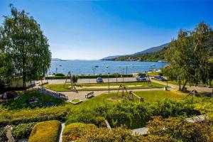 un parco con parco giochi accanto a un bacino d'acqua di Residenz La Vela a Baveno