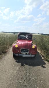 ein rotes Auto ist auf einer unbefestigten Straße geparkt in der Unterkunft Logement insolite avec Jeux et Jacuzzi in Soulosse-sous-Saint-Élophe