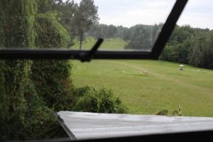 a view of a field from a window at Golf Course Apartment in Maseru