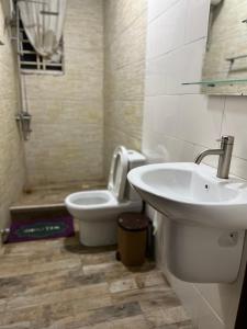 a bathroom with a sink and a toilet at Beatrice court in Accra