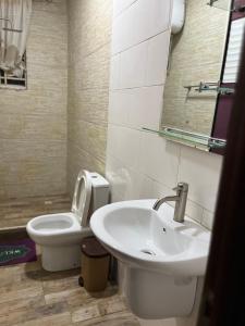 a bathroom with a sink and a toilet at Beatrice court in Accra