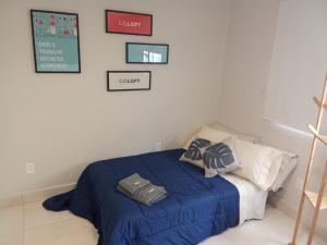 Un dormitorio con una cama con un edredón azul. en Hospedagem e Coworking - suítes, en Anápolis 8 fotos más