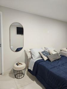 1 dormitorio con cama y espejo redondo en Hospedagem e Coworking - suítes, en Anápolis
