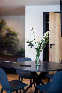 a vase of flowers sitting on a table with chairs at "Work and Quiet", Faktura VAT, KLIMATYZACJA, AIR CONDITIONING, GROUND FLOOR, PARKING, PARTER, in Kielce +2 photos