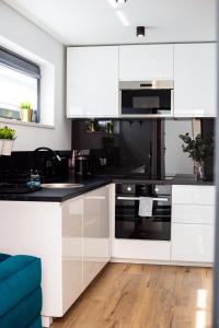 a kitchen with white cabinets and black appliances at "Work and Quiet", Faktura VAT, KLIMATYZACJA, AIR CONDITIONING, GROUND FLOOR, PARKING, PARTER, in Kielce