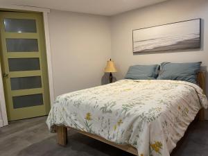 een slaapkamer met een bed en een groene deur bij La forêt nourricière in La Tuque