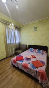 a bedroom with a bed and a couch and a window at Apartment in the city centr Bursatsky descent in Kharkiv