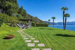 a grassy field with a pathway next to the water at Yachting Residence in Ghiffa