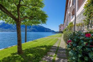 a sidewalk next to a building with a tree and water at Yachting Residence in Ghiffa +2 photos