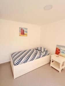 a white bedroom with a bed and a table at Serenity House Antón in Coclé