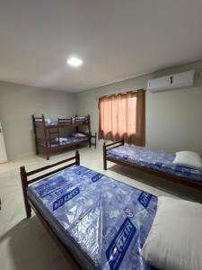 Un dormitorio con dos camas y una ventana. en Casa Foz do Iguaçu Ipê, en Foz do Iguaçu 18 fotos más