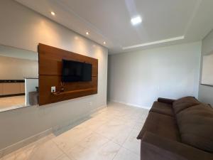 Una sala de estar con un sofá y un televisor de pantalla plana. en Casa Foz do Iguaçu Ipê, en Foz do Iguaçu