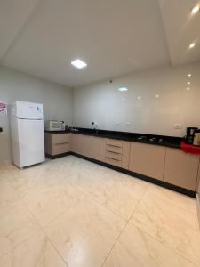 Una cocina grande y vacía con refrigerador y estufa. en Casa Foz do Iguaçu Ipê, en Foz do Iguaçu