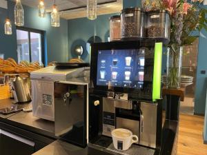 a coffee machine sitting on a counter with a coffee cup at Hotel Villa Erlen in Erlangen