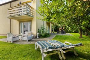 a patio with two chairs and a table in the grass at Villa LILIA in Międzywodzie