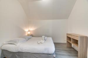 a bedroom with a bed and a wooden table at Le Hameau Paisible in Butot