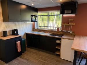 Una cocina con gabinetes negros y un fregadero. en chez isabelle et thierry, en Harnes 6 fotos más