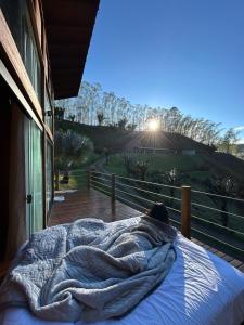 a person laying in a bed on a porch at Sítio Rancho Mineiro in Domingos Martins