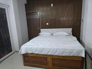 ein Schlafzimmer mit einem großen Bett mit einem hölzernen Kopfteil in der Unterkunft Yuvati Homestay in Bumlitan