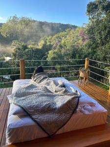 a person laying in a bed on a deck at Sítio Rancho Mineiro in Domingos Martins