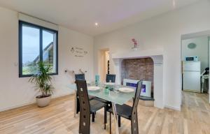 a dining room and kitchen with a table and chairs at Le Hameau Paisible in Butot