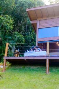 a man laying in a fake bed with a dog at Sítio Rancho Mineiro in Domingos Martins