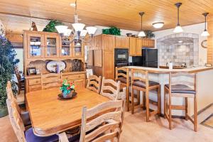 a kitchen with wooden cabinets and tables and chairs at Dulany 306 in Steamboat Springs
