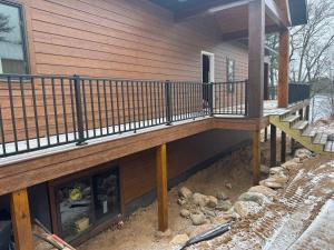 a wooden deck on a house with a porch at 5 Bdrm 12 Guest LakeHouse with Private Boat Dock in Round Lake Seaplane Base