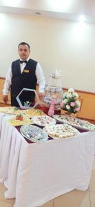 a man standing in front of a table with food at فندق عرفه الجديد in Tanta