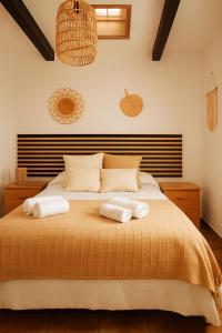 a bedroom with a bed with towels on it at Casa del Agua - Escapada rural con chimenea y vistas a Sierra Nevada in Abrucena
