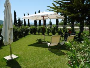 an umbrella and two chairs and a table and a table and a table and chairs at Dimora Aunti in Albinia