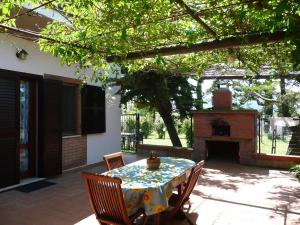 a patio with a table and a fireplace at Dimora Aunti in Albinia