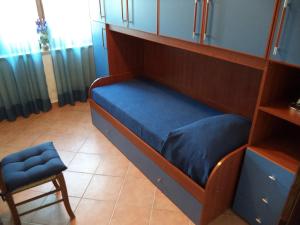 a bed with a blue pillow and a chair in a room at Dimora Aunti in Albinia +3 photos