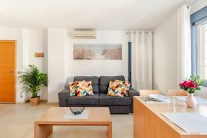 ein Wohnzimmer mit Sofa und Tisch in der Unterkunft Apartamentos Varadero on the beach in La Cala del Moral