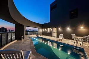 a swimming pool in a building with a blue light at Hotel Slaviero Grandflats Suíte Master Luxo in Sao Paulo