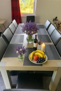 a table with a plate of fruit and a bottle of wine at Villa Slupečná in Lipno nad Vltavou
