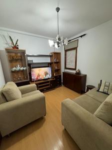 a living room with a couch and a flat screen tv at Family & Pet Friendly Beach Stay & Fast Wi-Fi in Figueira da Foz