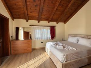 a bedroom with a bed and a wooden ceiling at Bujtina Tushaj in Lezhë