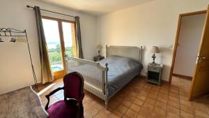una camera da letto con un letto, una sedia e una finestra di La Castagna Sea View Pool Villa a Coti-Chiavari Altre 17 foto