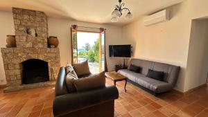 un soggiorno con divano e camino di La Castagna Sea View Pool Villa a Coti-Chiavari